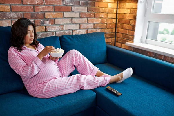 Adorável grávida do sexo feminino desfrutar assistindo tv em casa — Fotografia de Stock