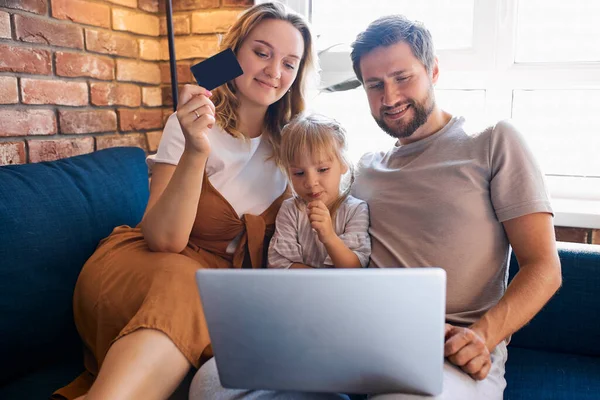 Familia caucásica sentarse usando el ordenador portátil en el sofá en casa —  Fotos de Stock