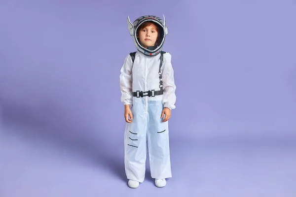 Портрет серйозної дитини астронавта в білому захисному костюмі і шоломі, дивлячись на камеру — стокове фото