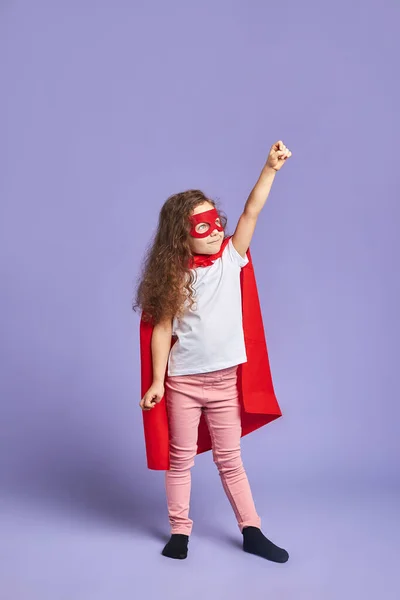 Niña vistiendo traje rojo y máscara se imagina a sí misma como superhéroe — Foto de Stock