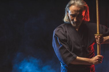 Dumanlı arka planda geleneksel giyinmiş kendo savaşçısı