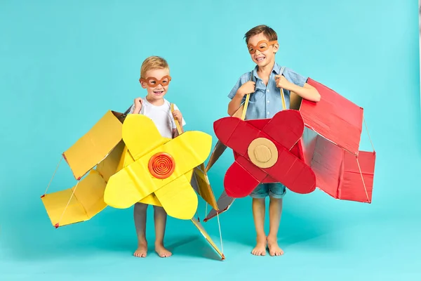 Милые маленькие мальчики в картонных самолетах — стоковое фото