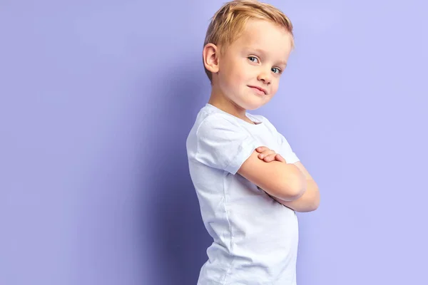 Vackert barn med blont hår och blå ögon isolerade på lila bakgrund — Stockfoto