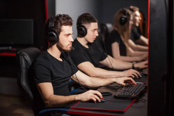 Young gamers playing video game while spending weekend at pc gaming club