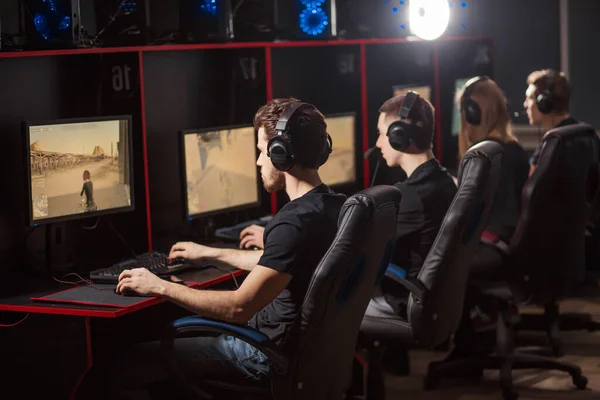 Backside of gamers participating in online cyber tournament, at pc gaming club. — Stock Photo, Image