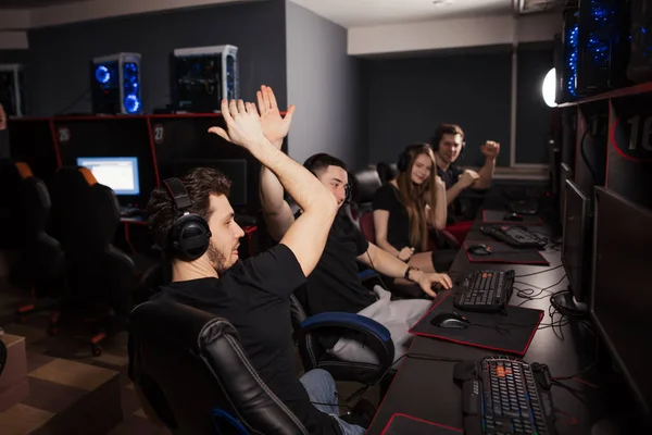 Joyful e-sport gamers celebram a vitória em computadores poderosos no centro de jogos . — Fotografia de Stock