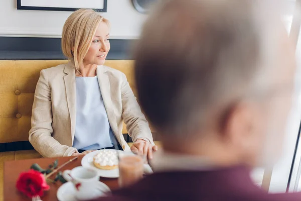 Attraktivt moget par tittar på fönstret medan du sitter i caféet — Stockfoto