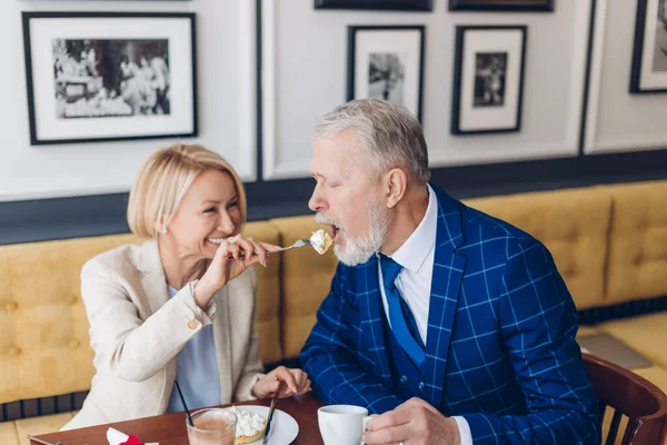 Senior lycklig familj par äta tårta i café tillsammans — Stockfoto