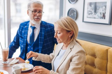 Yakışıklı adam güzel karısına bakıyor tatlıyı tadıyor.
