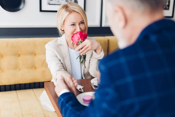 Любящая женщина с красивой розой и глядя на своего поклонника — стоковое фото
