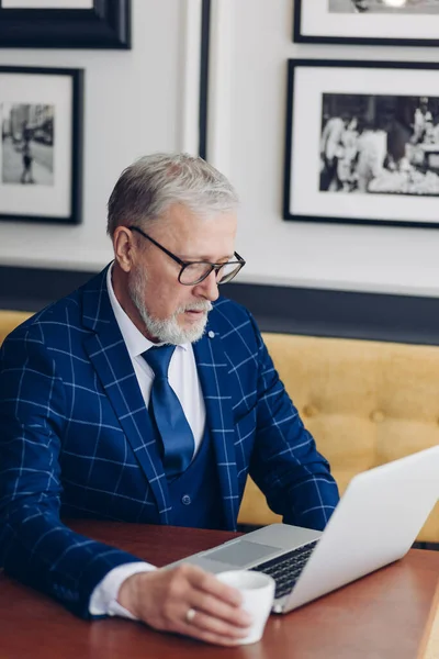 man in fashion suit sitting at the table