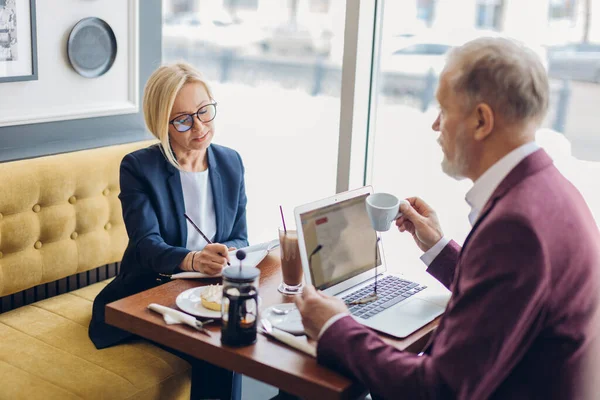 Mujer impresionante en ropa elegante y hombre viejo que tiene una reunión de negocios — Foto de Stock