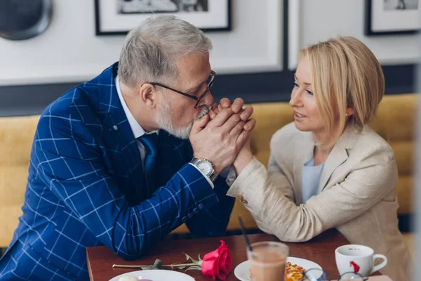 Kärleksfull man kysser sina kvinnor händer och visar sin känsla och kärlek — Stockfoto