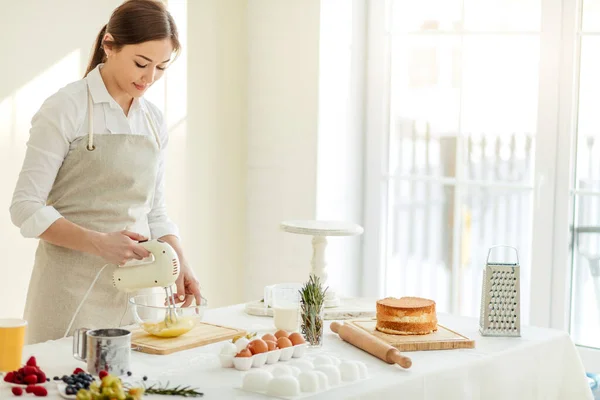 Joven chica agradable impresionante hornear un pastel en la cocina. —  Fotos de Stock