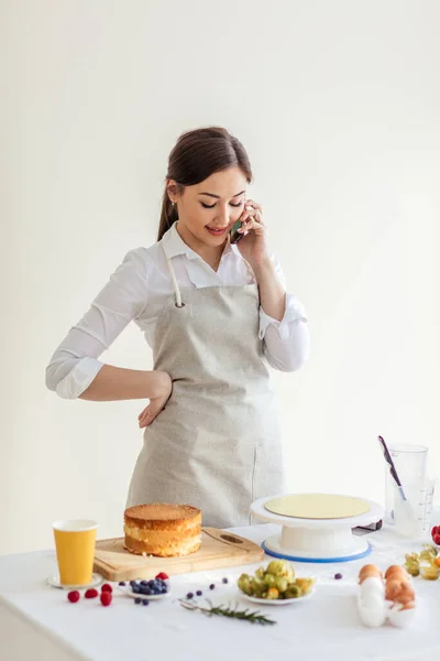 Hermosa chica de buen aspecto hablando con su boyriend mientras cocina en casa —  Fotos de Stock