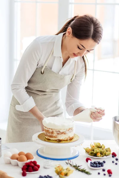 Concepto de pastelería casera. chica concentrada en la decoración de la torta. —  Fotos de Stock