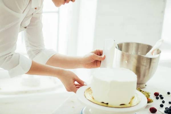 Talentosa mujer experimentada raspando el exceso de glaseado de la torta —  Fotos de Stock