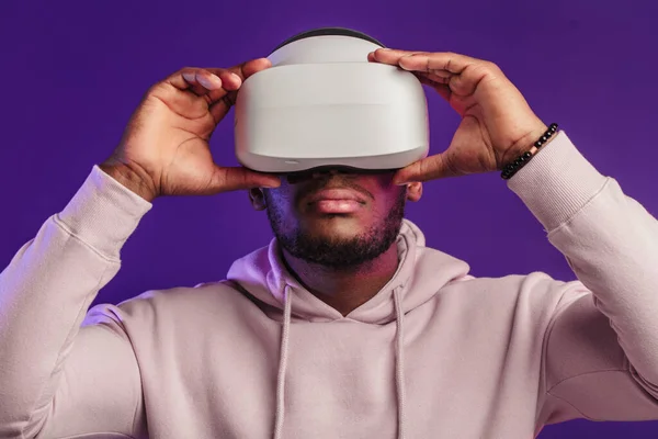 Afrykanin w wirtualnej rzeczywistości gogle izolowane na ciemnym fioletowym tle — Zdjęcie stockowe