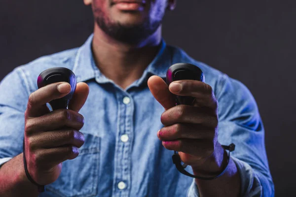 Afrikaanse man draagt virtual reality bril geïsoleerd op donker paarse achtergrond — Stockfoto