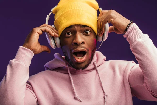 Afrikaanse man in hoodie met hoofdtelefoon geïsoleerd, gelukkige uitdrukking. Muziek, mensen. — Stockfoto