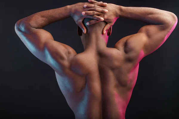 Atleta masculino africano com tronco nu posando contra a parede escura. Foto chave baixa . — Fotografia de Stock