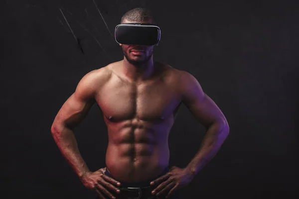 Uomo africano con corpo muscolare atletico indossando cuffie realtà virtuale. — Foto Stock