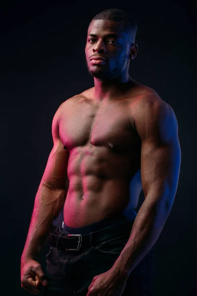 Fit young African sports king man with torso, isolated on dark background. — Stock Photo, Image