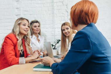 Takım çalışması. Çok ırklı kadınlar açık uzay ofisinde toplanıyor..