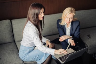 Ofisteki dizüstü bilgisayarla çalışan iki ciddi çalışanı kapatın.