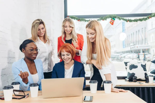 Red-haired teacher explaining new material on economics to female students. — Stock Photo, Image