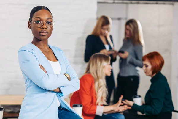 Business zwart vrouw aanpassen van haar kleren op een grijze achtergrond — Stockfoto