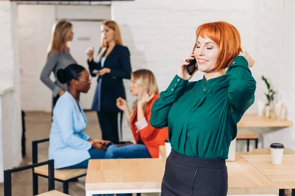 Portret van een jonge roodharige vrouw met een bril tegen een blauwe achtergrond — Stockfoto