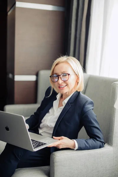 Portrait of a attractive blonde business woman at office working on laptop