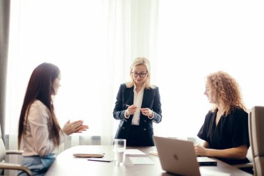 İş arkadaşları iş planlarını tartışıyor, ofis masasında oturuyor..