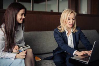 Ofisteki dizüstü bilgisayarla çalışan iki ciddi çalışanı kapatın.