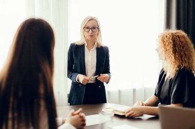 İş arkadaşları iş planlarını tartışıyor, ofis masasında oturuyor..