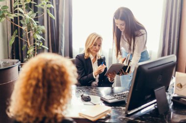 Ofiste iş arkadaşlarıyla görüşürken kadın denetleyici belgeyi imzalıyor