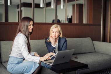 Ofisteki dizüstü bilgisayarla çalışan iki ciddi çalışanı kapatın.