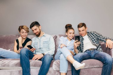 Gençler birbirleriyle konuşmak yerine aletlerine bakıyorlar.