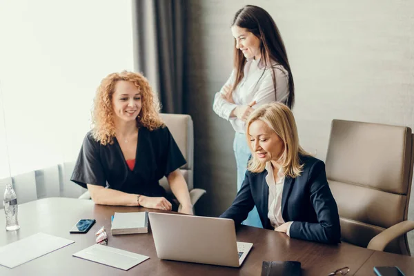 Tres mujeres de negocios enfocadas trabajando juntas, lluvia de ideas en la oficina. — Foto de Stock