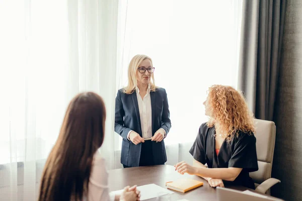 Grupo de mujeres de negocios reunidas en la oficina, compartiendo ideas, semana de planificación. — Foto de Stock