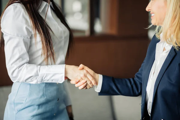 Due donne d'affari che si stringono la mano mentre chiudono una partnership, si concentrano sulle mani — Foto Stock