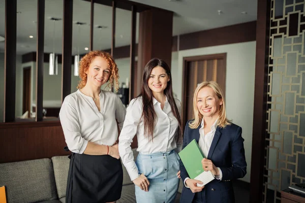 Retrato de tres mujeres de negocios caucásicas en ropa formal en el vestíbulo de un hotel — Foto de Stock