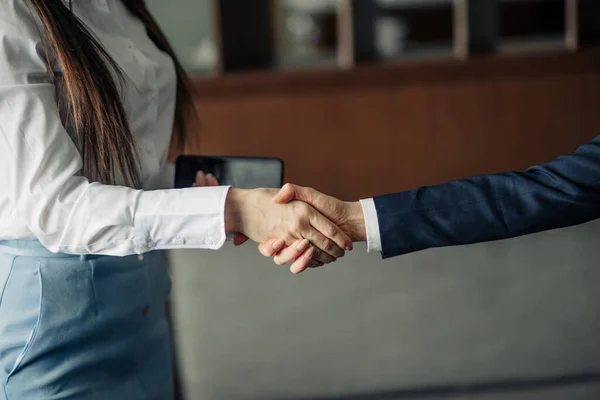 Two businesswomen shaking hands as they close a partnership, focus on hands — Stock Photo, Image
