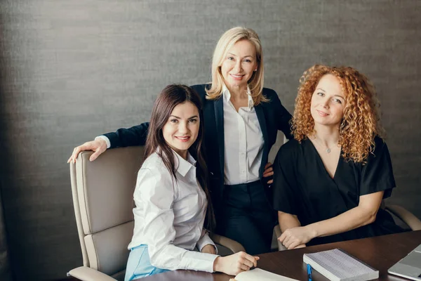 Tres mujeres de negocios enfocadas con diferentes peinados trabajan juntas en la oficina. —  Fotos de Stock