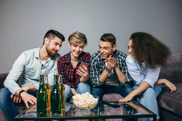 Jóvenes alegres están mirando a la pantalla del teléfono inteligente — Foto de Stock