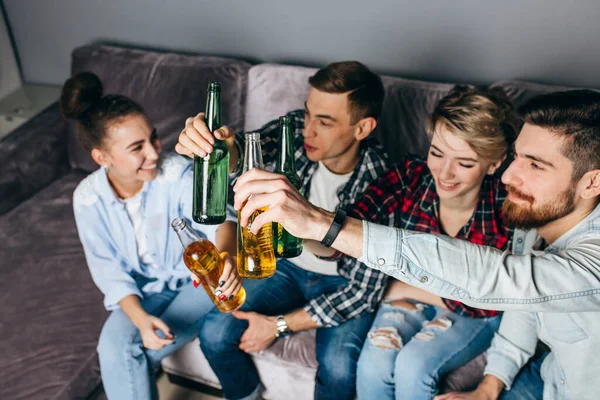 Felici giovani donne e uomini in abiti alla moda stanno bevendo bevande alcoliche — Foto Stock