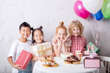 Sarışın küçük kız doğum gününü melez sınıf arkadaşlarıyla geçiriyor.