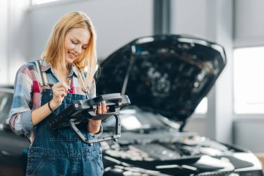 Kadın tamirci araba tamirhanesinde yüksek lisans yapıyor.