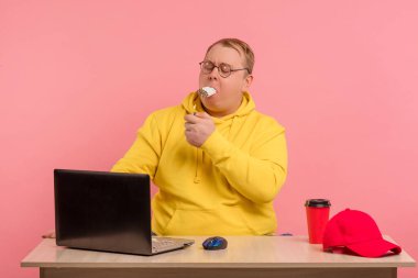 Stresli şişman bir adam aynı anda bir yığın sigara içmeye çalışıyor.